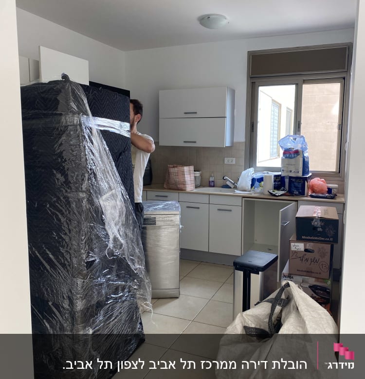 אדם עוטף רהיטים בניילון למעבר דירה